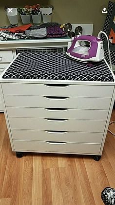 an ironing board sitting on top of a dresser