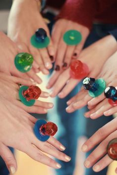 many different colored rings in the middle of each other with their hands holding them together