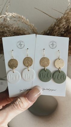 three different earrings are shown in front of a card