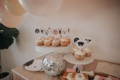 a table topped with cupcakes covered in frosting