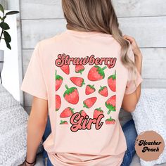 Welcome to the world of the cute and stylish "Strawberry Girl" shirt! With a cool design of juicy strawberries on the back and the trendy "Strawberry Girl" lettering, this shirt is an absolute must-have for all strawberry lovers out there. Show your love for this favorite fruity fruit and rock this summer with a touch of groove and freshness. Get your 'Strawberry Girl' shirt now and be ready to turn heads ♥ PRODUCTION TIME: 1-5 days (Usually 2-3 days)   ♥ SHIPPING TIME: 2-5 days (Usually 3 days) Cute Pink T-shirt With Strawberry Print, Trendy Funny Print Shirt For Spring, Trendy Spring Shirt With Funny Print, Sweet Short Sleeve Tops With Fruit Print, Cute Cotton Tops With Fruit Design, Trendy Red Tops With Strawberry Print, Trendy Spring Tops With Strawberry Print, Trendy Red T-shirt With Strawberry Print, Trendy Fruit Design Tops For Spring