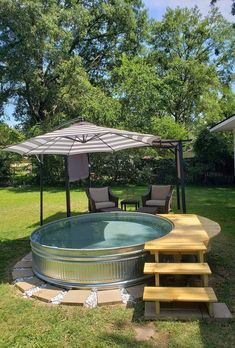 an outdoor hot tub in the middle of a yard with steps leading up to it