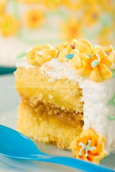 a piece of yellow cake with white frosting and sprinkles