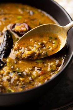 a spoon full of lentil soup in a pan