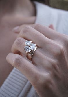 a close up of a person wearing a gold ring with two diamonds on the middle