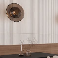 a black table with two vases on it and a clock hanging from the wall