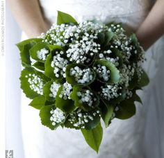 a bride holding a bouquet of baby's breath