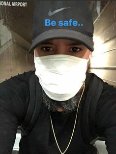 a man wearing a face mask with the words be safe on it