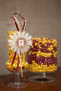 two glass vases with candy in them on a table