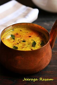 a wooden bowl filled with soup on top of a table