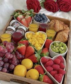 a wooden tray filled with fruit and pastries