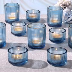 blue glass candles are lined up on a table