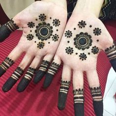 two hands with hendi designs on them, one is black and the other is white