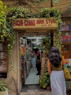 a woman standing in front of a book store