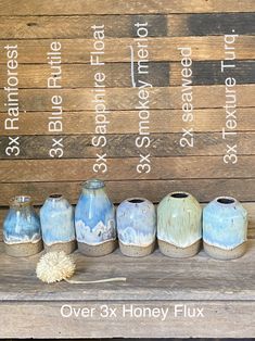 seven vases are lined up on a wooden bench with the words over 3x honey flux