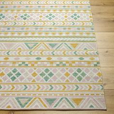 an area rug with different colors and patterns on the wooden floor in front of a door