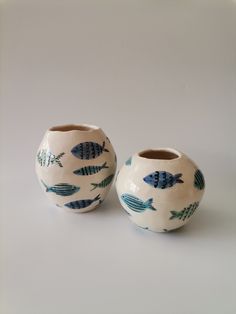 two blue and white vases with fish on them