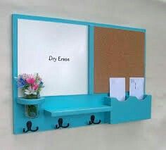 there is a blue shelf with two hooks on it and a flower in a vase