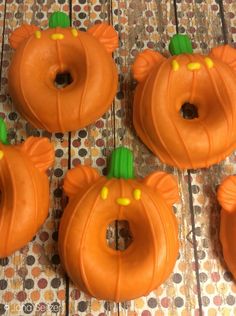 four pumpkin shaped donuts sitting on top of a table