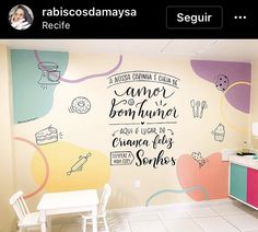 a kitchen wall with some writing on it and a table in front of the wall