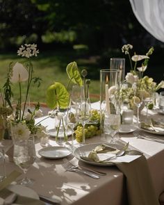 the table is set with white flowers and greenery for an elegant wedding reception or special event