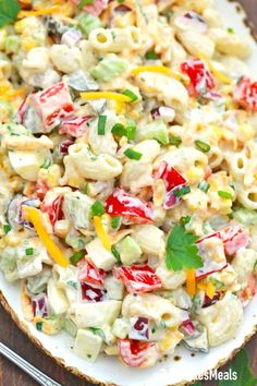 a plate filled with pasta salad on top of a wooden table