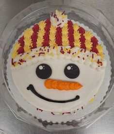 a frosted cake decorated with a snowman's face