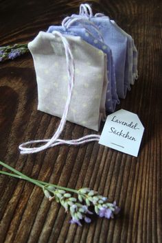 three lavender sacs are sitting on a wooden table next to a small tag that says lavender sketcheon