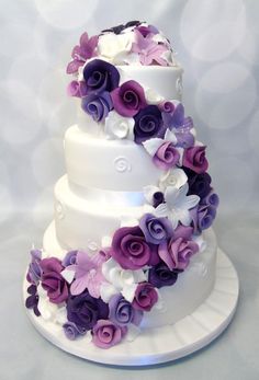 a wedding cake decorated with purple and white flowers