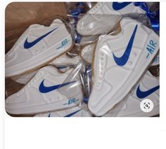 the nike air force sneakers are wrapped in plastic and have blue letters on them,