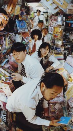 a group of young men standing next to each other in front of a pile of boxes