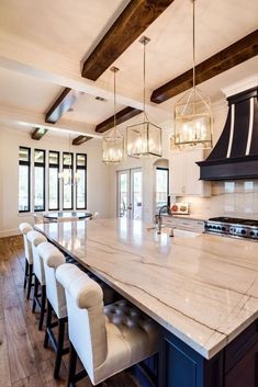 a large kitchen with marble counter tops and white chairs around the center island in front of an oven