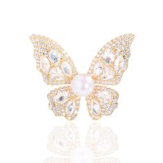 Embrace elegance with our Butterfly Brooch, featuring a radiant 8-9mm freshwater pearl nestled among sparkling cubic zirconia. Available in gold and silver finishes, this exquisite piece adds a touch of sophistication to any outfit. A perfect gift to symbolize transformation and beauty Material: Gold plated on brass, cubic zirconia, and freshwater pearls Pearl Size: 8-9mm Note: Our jewelry is handmade. Naturally formed shapes of freshwater baroque pearls may vary. The actual product may be sligh Gold Diamond Brooches As Gift, White Crystal Brooch For Anniversary, Elegant Gold Brooches With Diamond Accents, Elegant Gold Diamond Brooch, Exquisite White Wedding Brooches, Elegant Crystal Wedding Brooches, Glamorous Crystal Brooch As Gift, Glamorous Crystal Brooches For Gifts, Glamorous Crystal Brooches As Gift