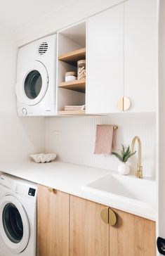 a washer and dryer sitting in a kitchen next to a counter with dishes on it