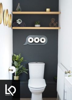 a white toilet sitting in a bathroom next to a wooden shelf filled with potted plants