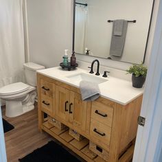 the bathroom is clean and ready for us to use it's natural wood cabinetry