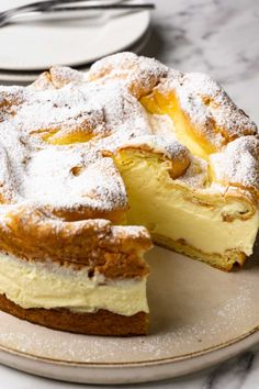 a cake with powdered sugar on top is sitting on a plate next to a fork