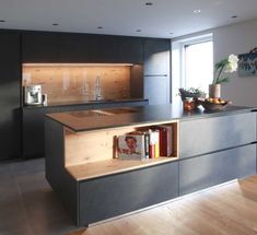 a kitchen with an island and bookshelf in it