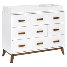 a white dresser with gold handles and drawers on it's sides, against a white background