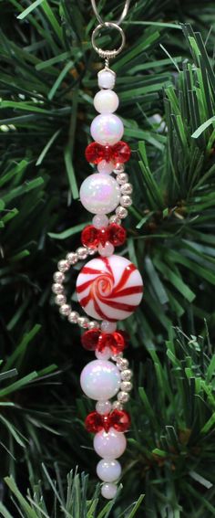 an ornament hanging from a christmas tree with candy canes and beads on it