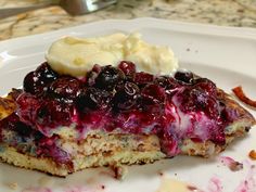 a piece of blueberry cheesecake on a plate with some ice cream and bananas