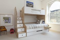 there is a bunk bed with stairs and drawers in the room, next to a window