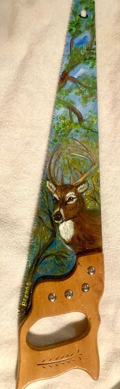 a wooden knife holder with a deer on it's face and trees in the background