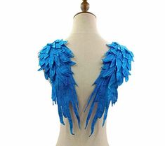 a white mannequin with blue feathers on it