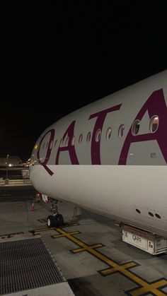 an airplane is parked on the tarmac at night