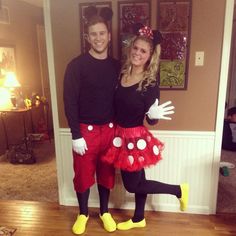 a man and woman in mickey mouse costumes