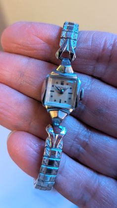 "This is a beautiful Benrus ladies watch that is currently working! I am not a watch expert, nor have I had it tested or serviced, it is being sold AS IS. I've wound it several times and it keeps fairly good time, not perfect, but ok.  I would strongly recommend having it serviced by a professional. The square face has a pearly white face with silver hands and numerals. The watch screams DECO! This watch is approximately 6.5\" with an etched stretch band. The watch is marked 10k RGP.  Given the age of the watches there will be scuffs and scratches, I do my best to highlight them in the pics and detail them in the description so there are no unpleasant surprises after purchase! This one is really lovely!! This bracelet makes a statement and are perfect for anyone who loves vintage or steamp Square Face, Stretch Band, Square Faces, Stretch Bands, White Face, Women Wrist Watch, Steampunk Fashion, Jewelry Cleaner, Ladies Watch