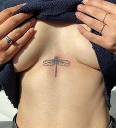 a woman with a dragonfly tattoo on her stomach