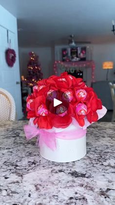 a red flower arrangement sitting on top of a counter