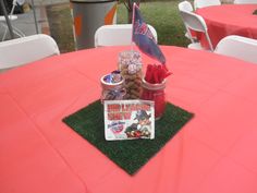 the table is set up for an event with pink linens and decorations on it